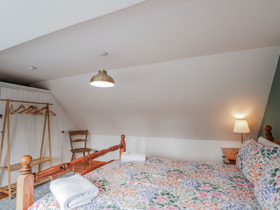 A bedroom with a bed and a clothes rack at Achnagonlin House, Grantown-on-Spey
