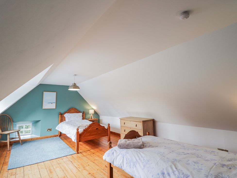A bedroom with two beds and a chair at Achnagonlin House in Grantown-on-Spey