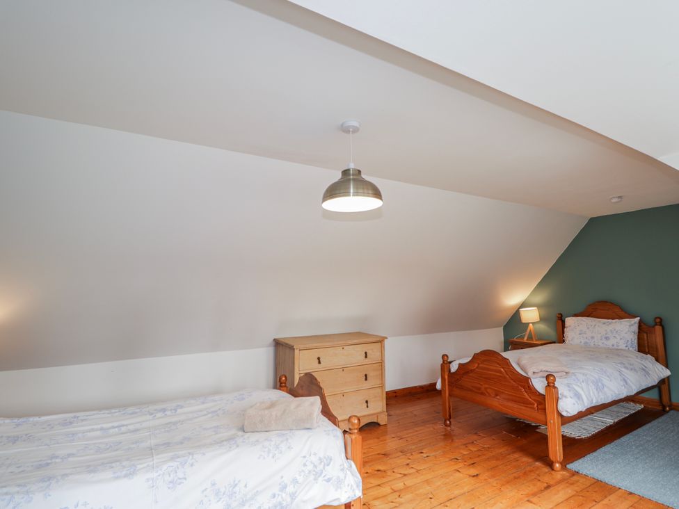 A bedroom with two beds and a dresser at Achnagonlin House Grantown-on-Spey