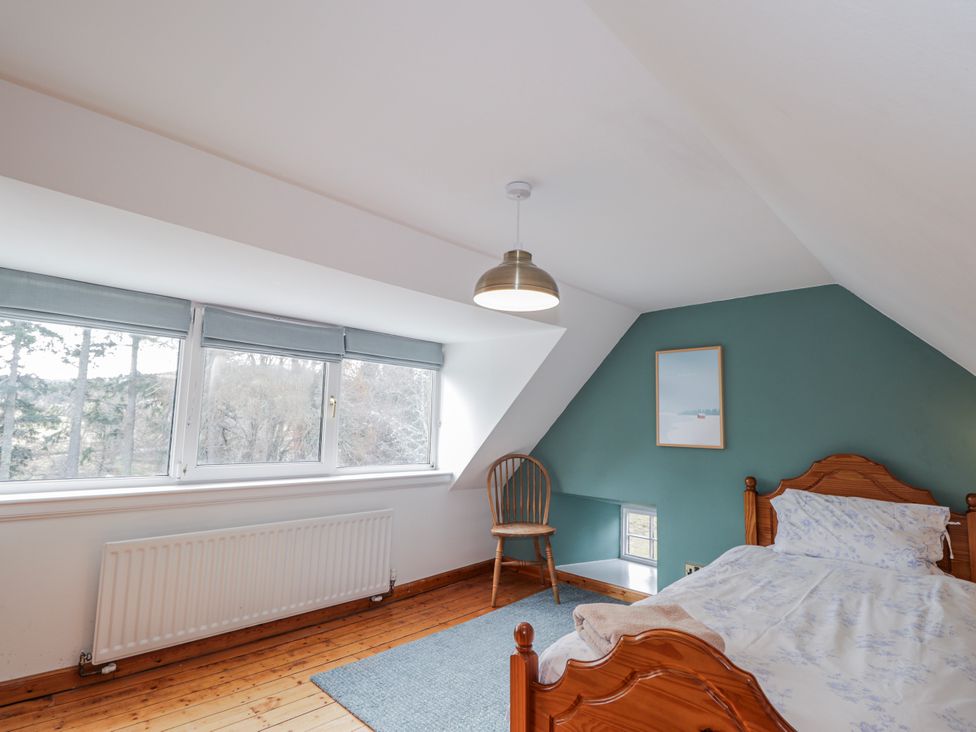 A bedroom with a bed and chair at Achnagonlin House in Grantown-on-Spey