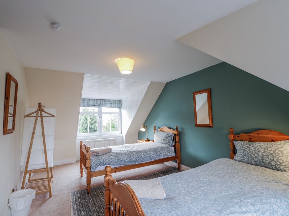 A bedroom with two beds and a window at Achnagonlin House in Grantown-on-Spey