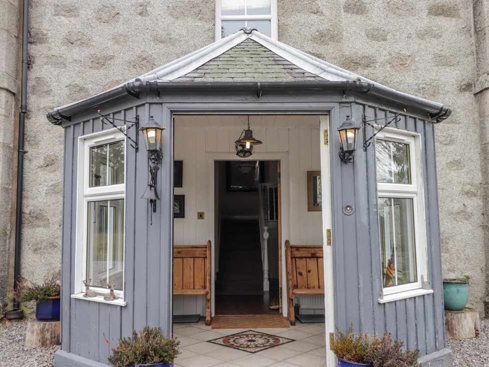 An entryway with benches and a staircase at Achnagonlin House in Grantown-on-Spey