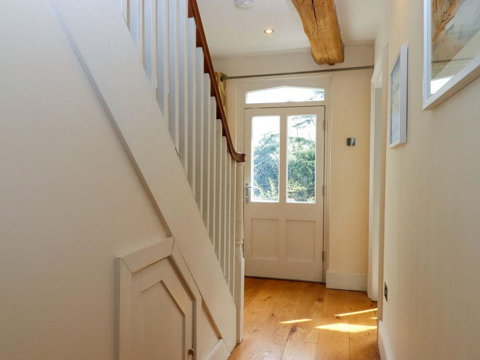 A hallway with a staircase and a front door at The Mill House in Newton Abbot