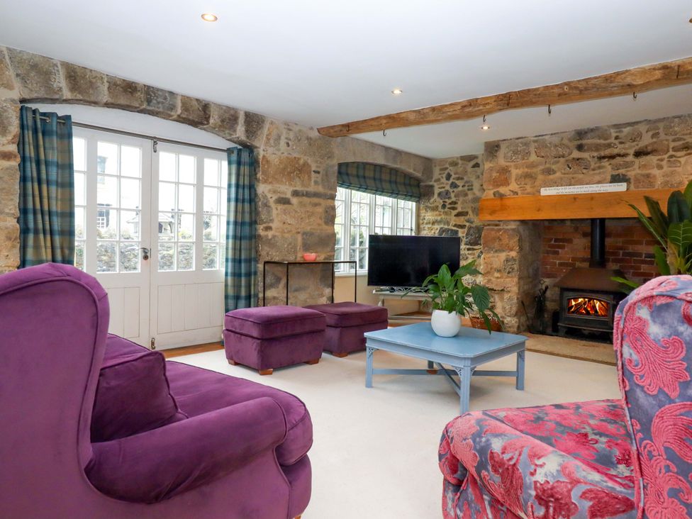 A living room with a sofa and television at The Mill House in Newton Abbot