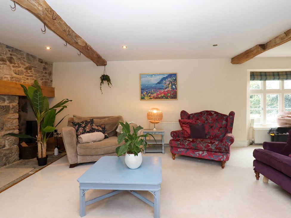 A living room with a sofa and armchairs at The Mill House in Newton Abbot