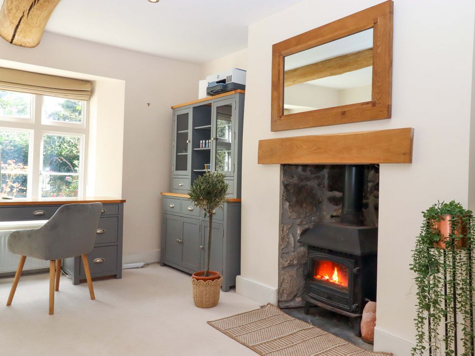A study room with a desk and a fireplace at The Mill House in Newton Abbot