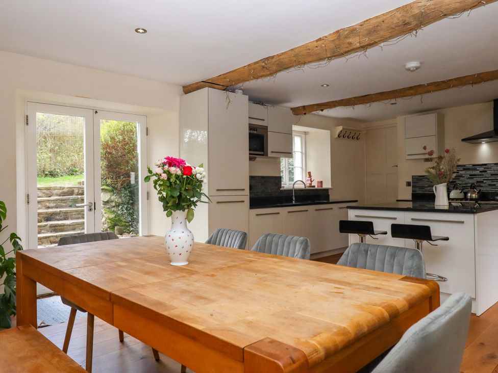 A kitchen with a wooden table and chairs at The Mill House in Newton Abbot