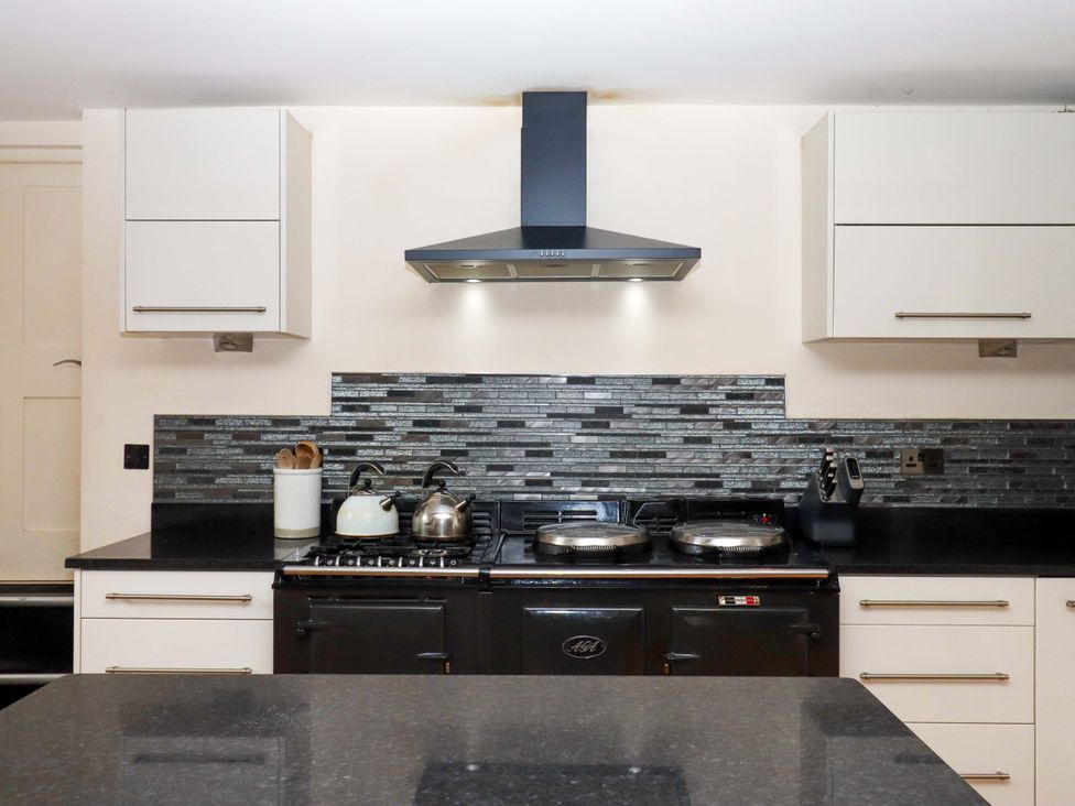 A kitchen with stove and sink at The Mill House in Newton Abbot