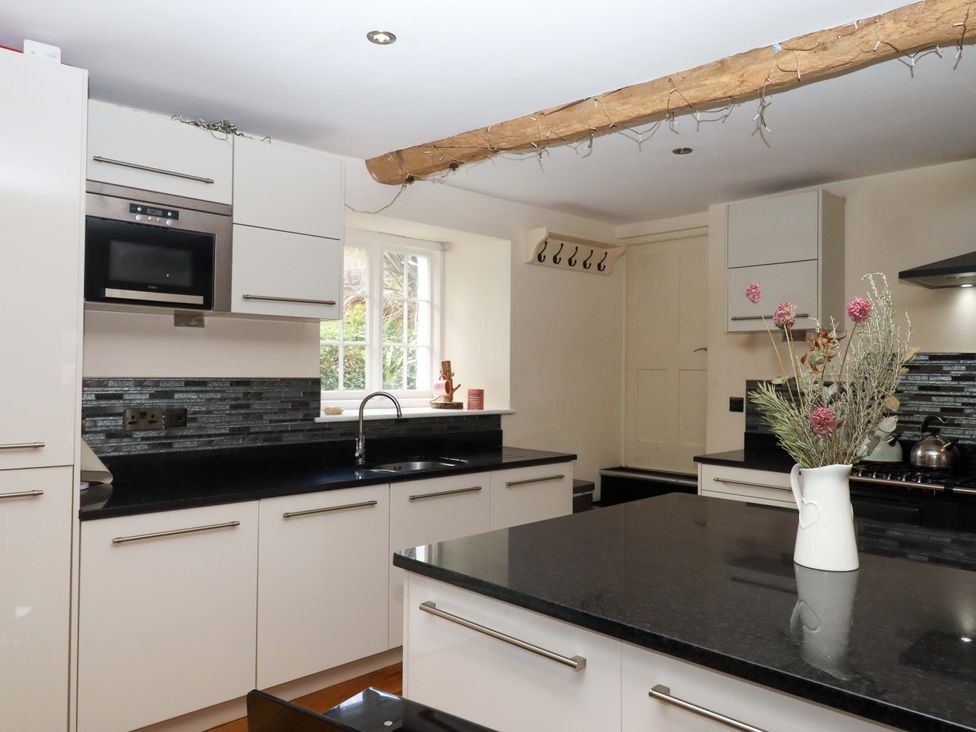 A kitchen with cabinets, a sink, and a stove at The Mill House in Newton Abbot