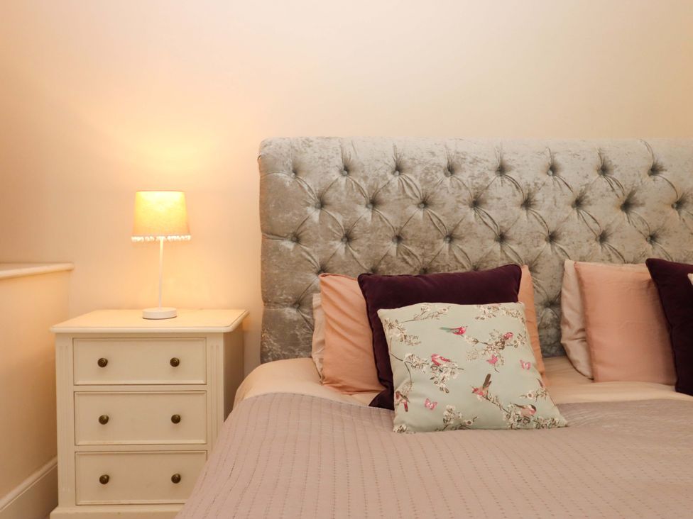 A bedroom with a bed and bedside table at The Mill House in Newton Abbot