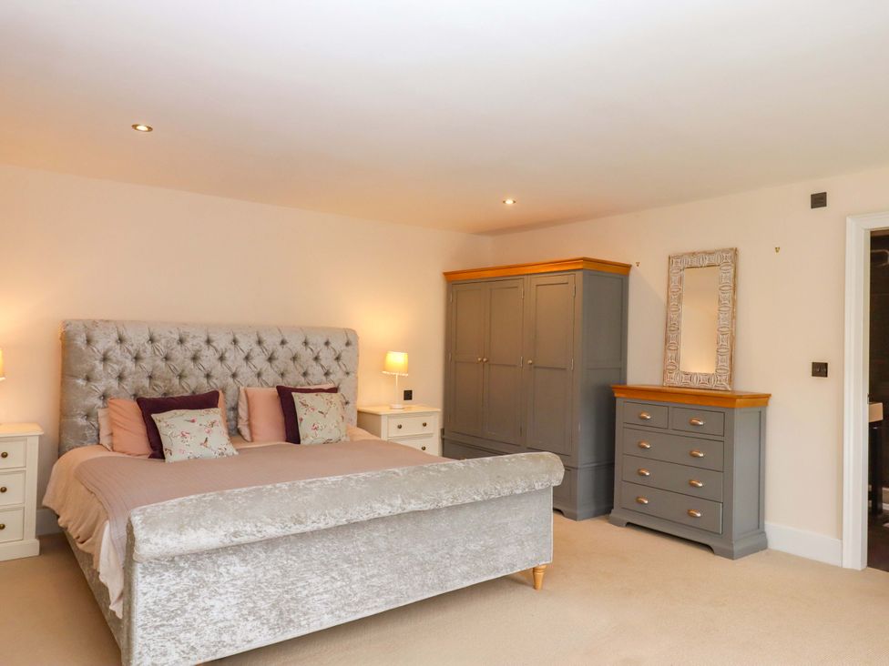 A bedroom with a bed and wardrobe at The Mill House in Newton Abbot