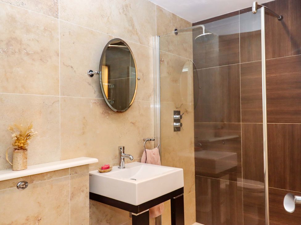 A bathroom with a shower and sink at The Mill House in Newton Abbot