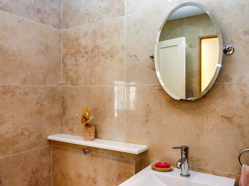 A bathroom with a sink and mirror at The Mill House in Newton Abbot