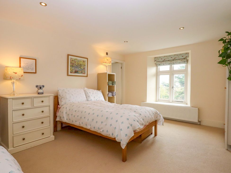 A bedroom with two beds and a window at The Mill House in Newton Abbot