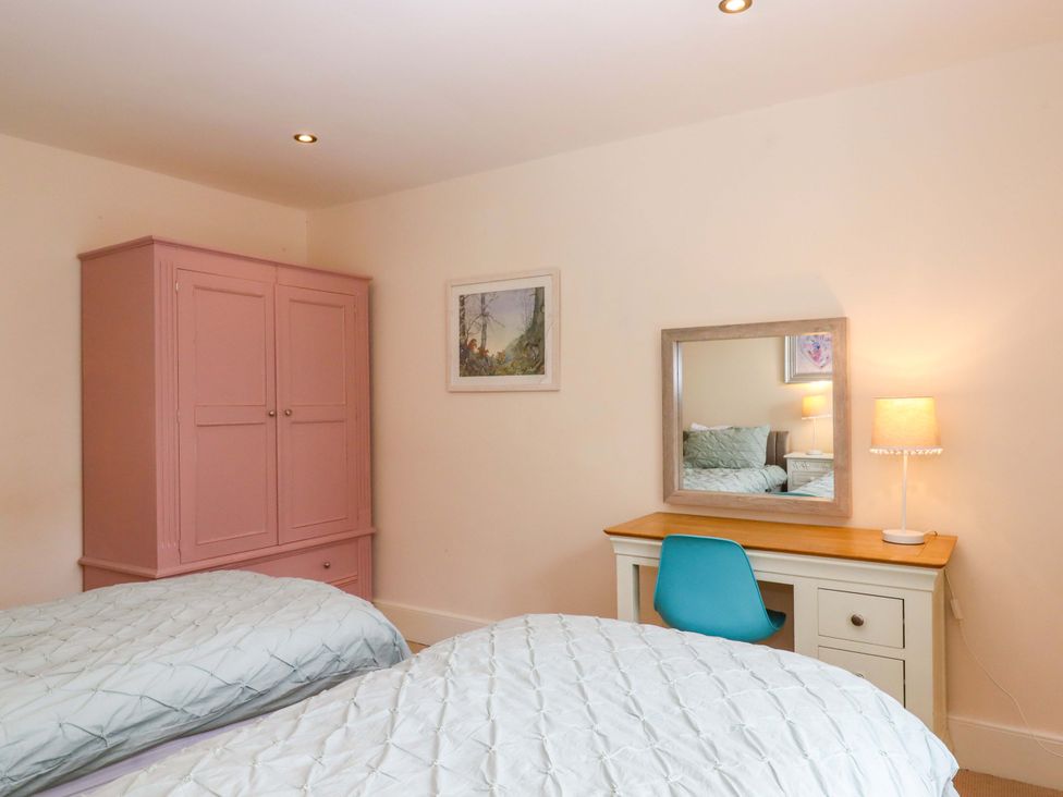 A bedroom with two beds and a desk at The Mill House in Newton Abbot