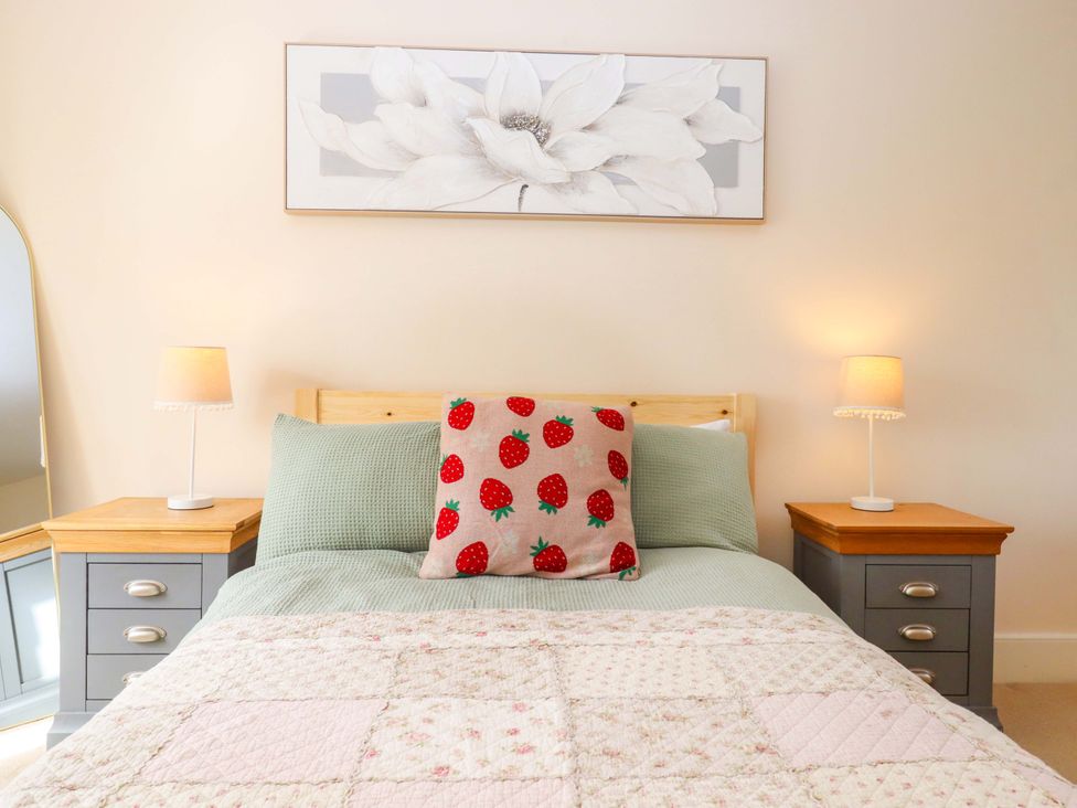 A bedroom with a bed and bedside tables at The Mill House in Newton Abbot