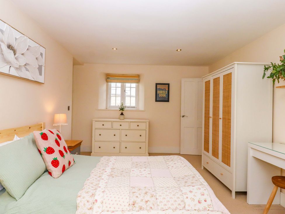 A bedroom with a bed and furniture at The Mill House in Newton Abbot
