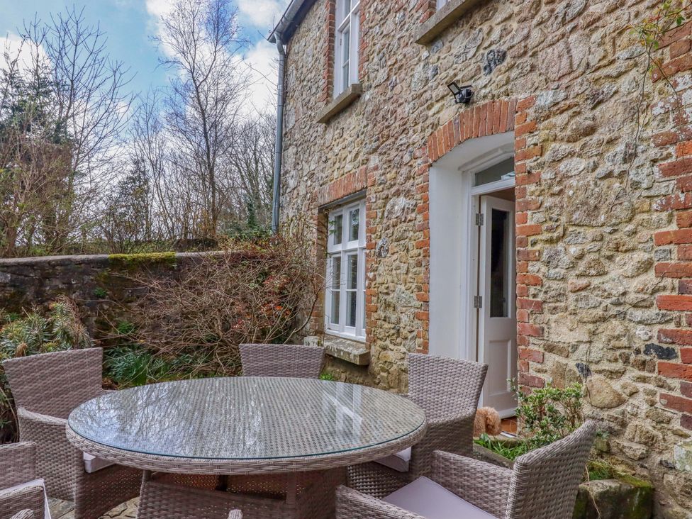 An outdoor seating area with a table and chairs at The Mill House in Newton Abbot