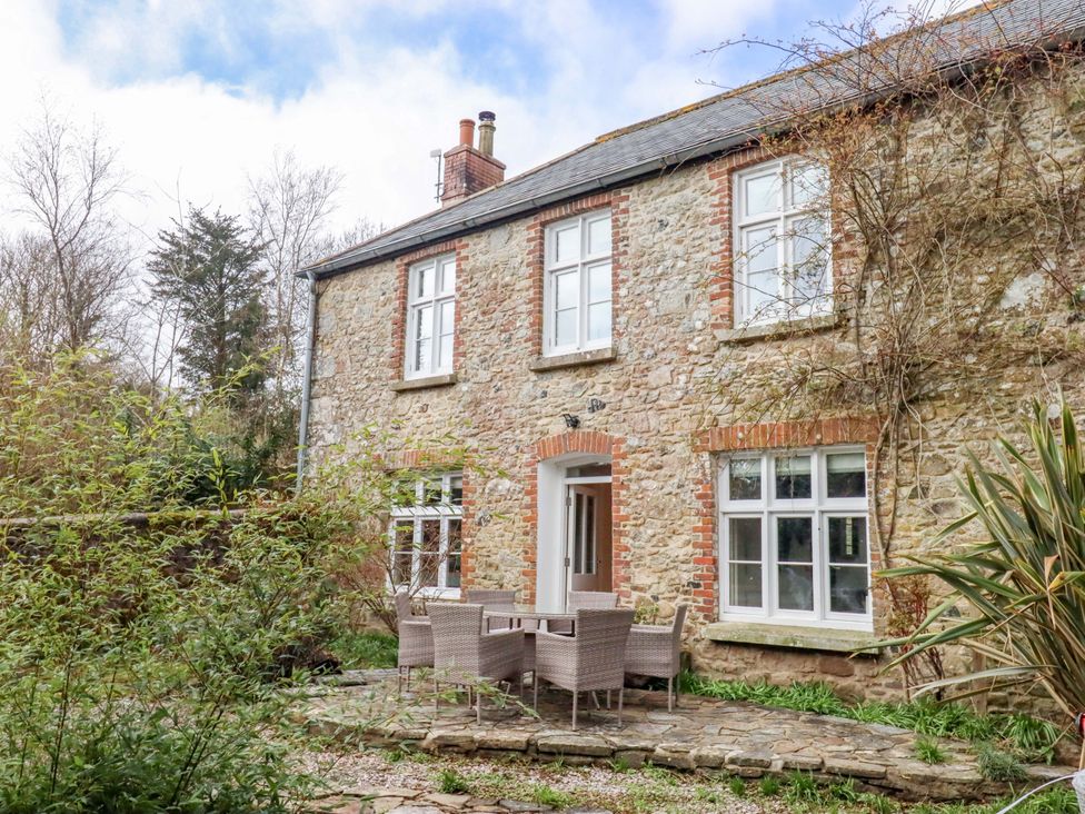 An outdoor area with a table and chairs at The Mill House in Newton Abbot