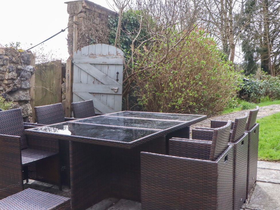 A garden with a table and chairs at The Mill House in Newton Abbot
