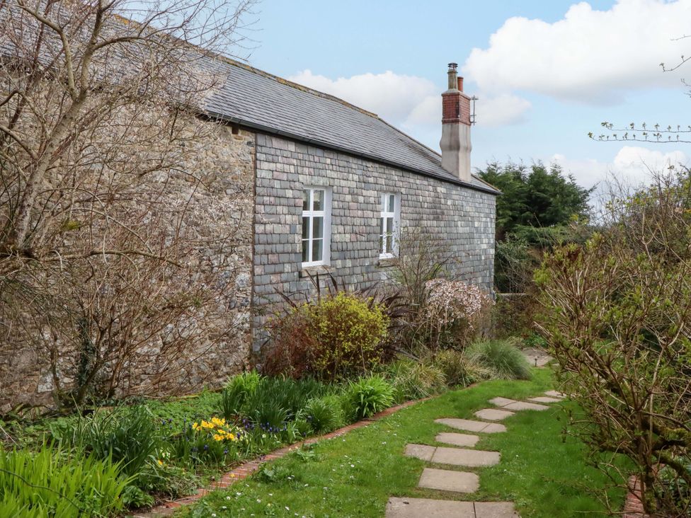 A garden with pathway and stone wall at The Mill House in Newton Abbot