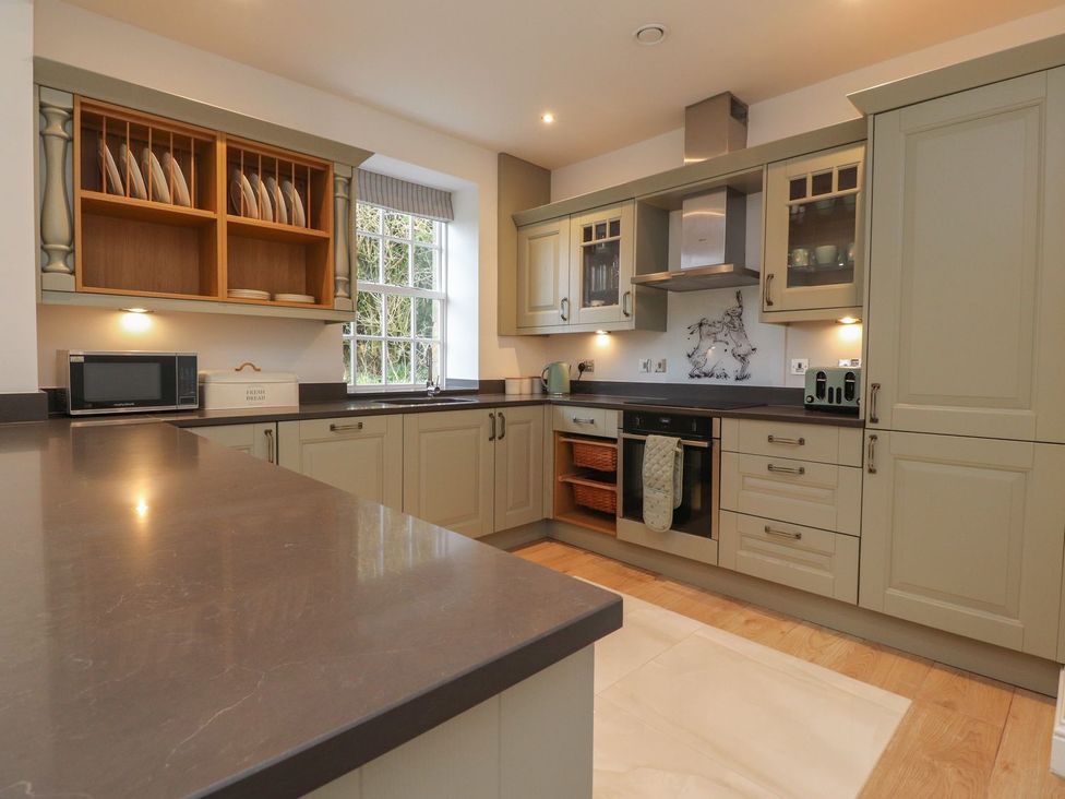 A kitchen with cabinets and appliances at The Lodge House in Dolphinholme near Galgate
