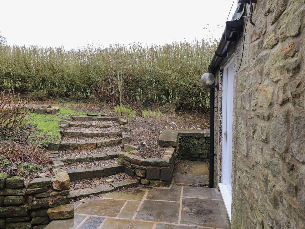 An outdoor garden area with stone steps and a wall at The Lodge House in Dolphinholme near Galgate