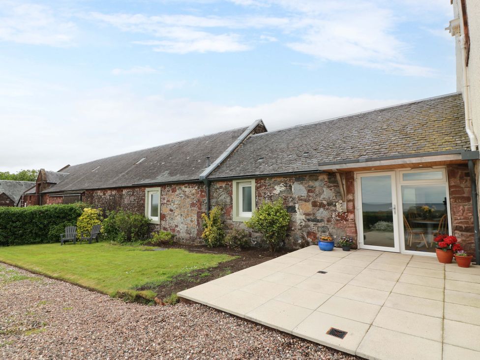 An outdoor patio area with garden and chairs at Burnside Bothy near Girvan