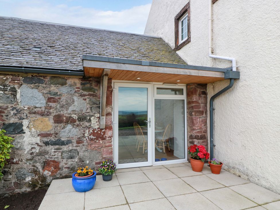 An outdoor area with a door and seating at Burnside Bothy near Girvan