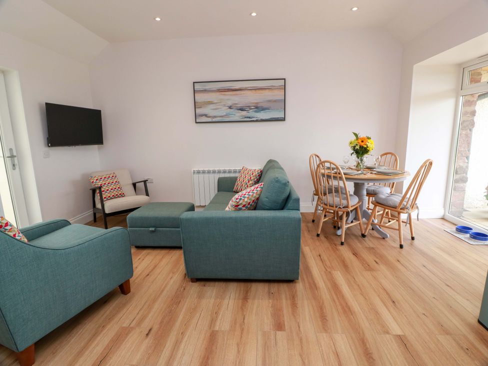 A living room with a sofa, armchairs, and a dining table at Burnside Bothy Burnside Farm near Girvan