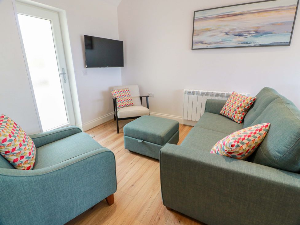 A living room with a sofa and armchair at Burnside Bothy Burnside Farm near Girvan