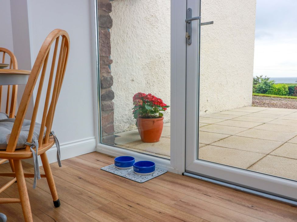 A dining room with a table and a flower pot at Burnside Bothy in Burnside Farm near Girvan