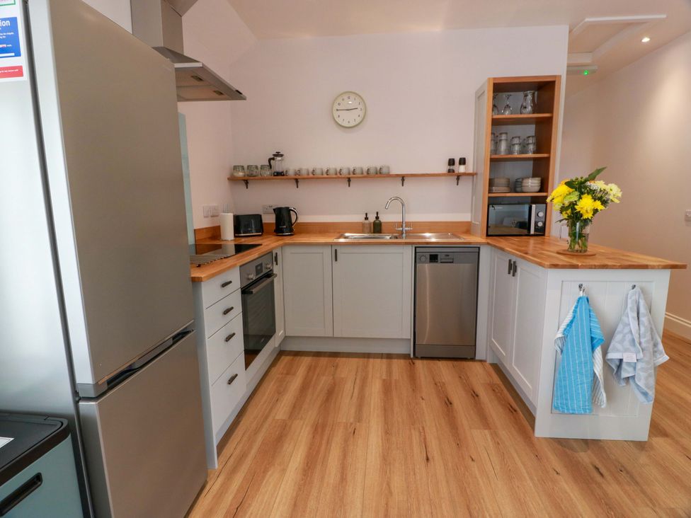 A kitchen with a refrigerator, oven, and sink at Burnside Bothy near Girvan