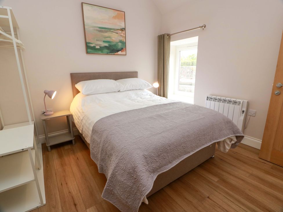 A bedroom with a bed and a bedside table at Burnside Bothy near Girvan