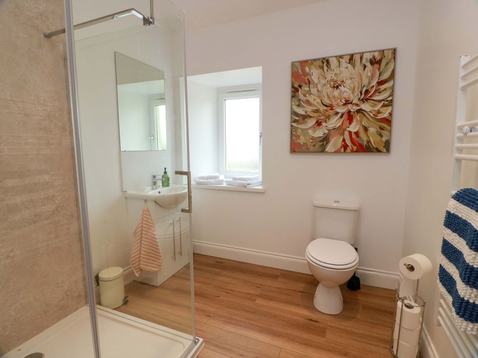 A bathroom with a shower, toilet, and sink at Burnside Bothy near Girvan