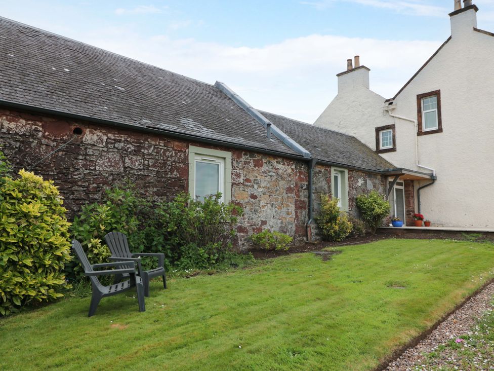 An outdoor area with a house and seating at Burnside Bothy near Girvan