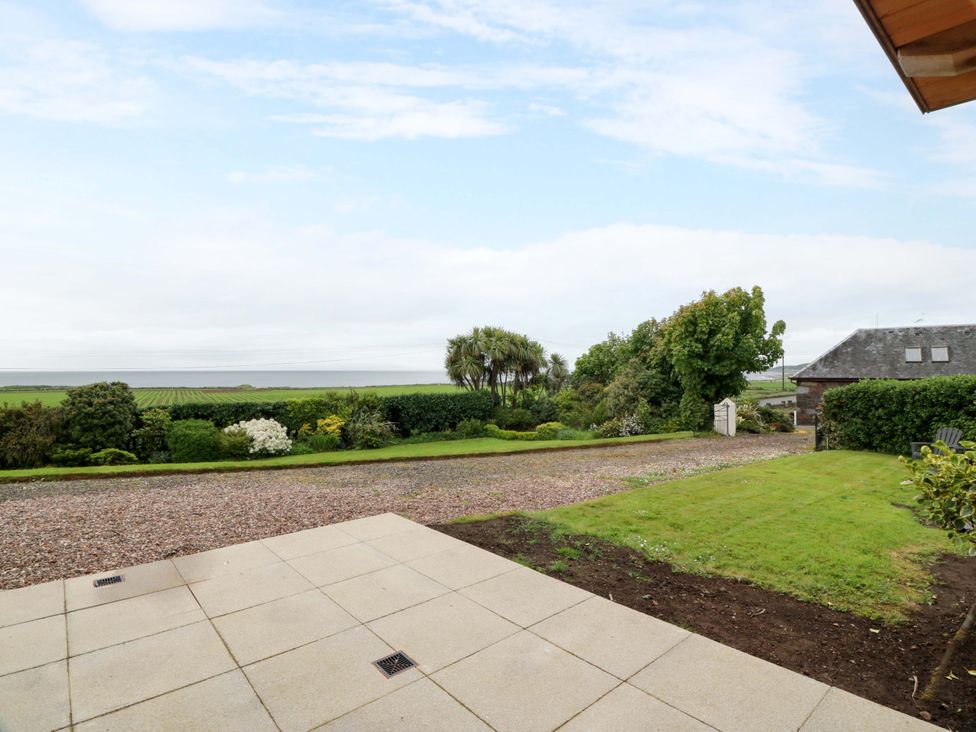 An outdoor area with a paved space and greenery at Burnside Bothy near Girvan