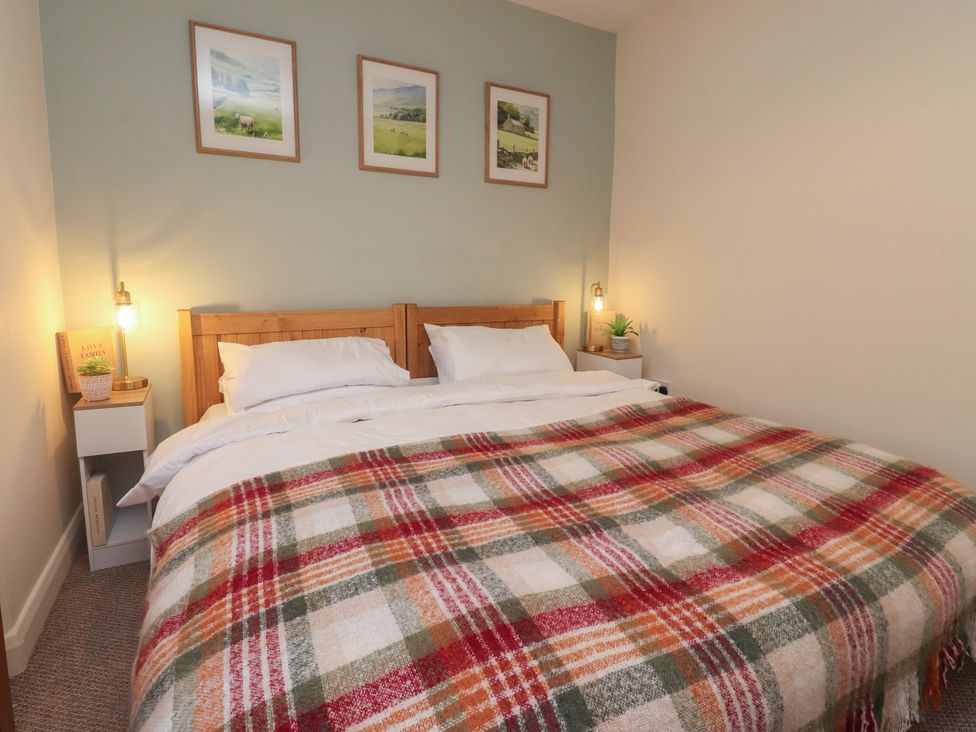 A bedroom with a bed covered in a blanket at Willow Wood in Settle