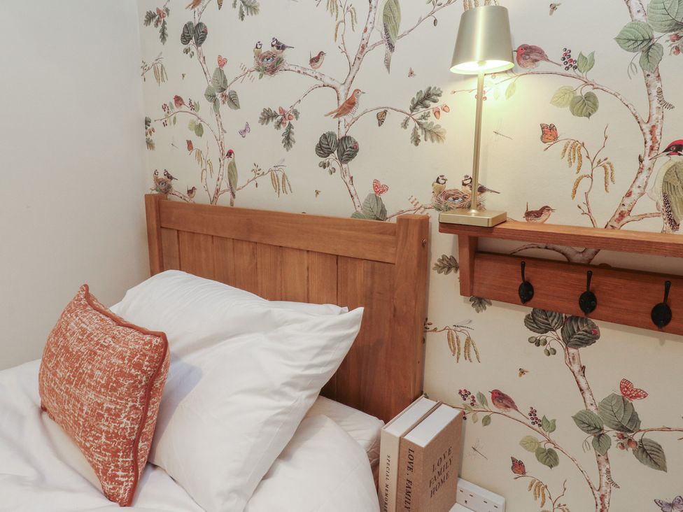 A bedroom with a bed and wooden shelf at Willow Wood, Settle
