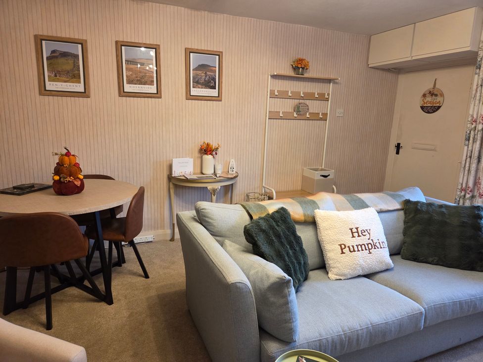A living room with a sofa and dining table at Willow Wood in Langcliffe near Settle