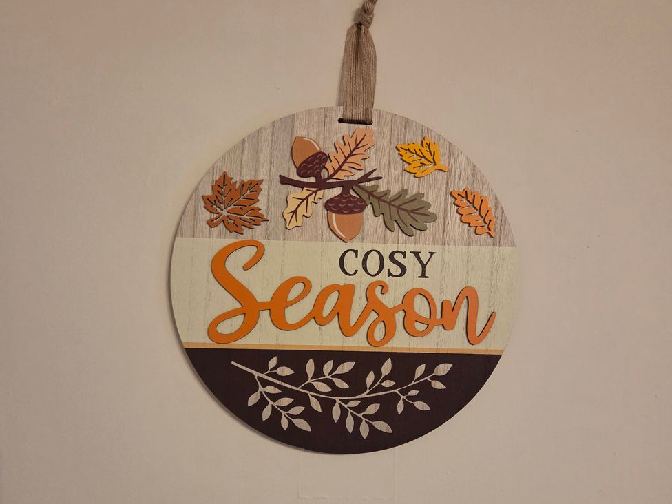 A decorative sign with the words Cosy Season and autumn-themed elements at Willow Wood in Langcliffe near Settle