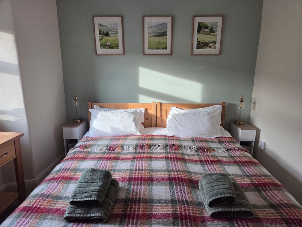 A bedroom with a bed and artwork on the wall at Willow Wood in Langcliffe near Settle