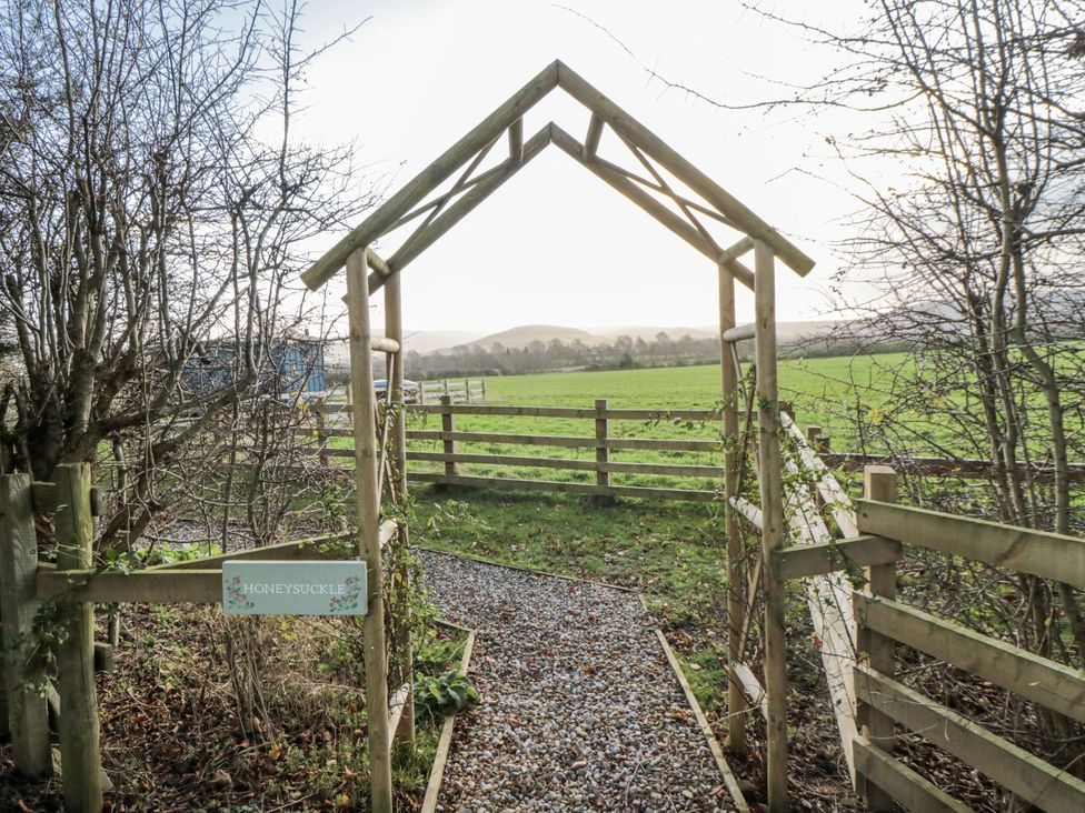 A pathway leading through a gateway labeled Honeysuckle at Honeysuckle Hut, Potto Grange Farm, Northallerton
