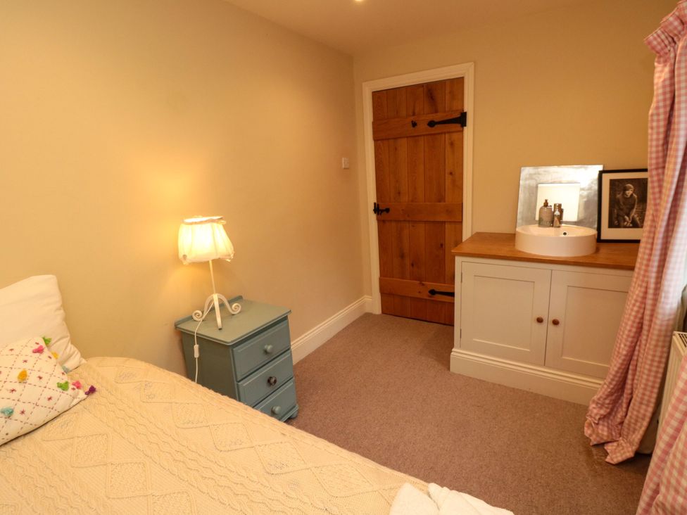 A bedroom with a bed, a nightstand, and a sink at St. Anthonys in York