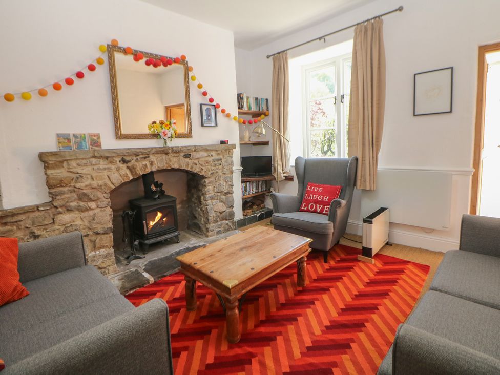 A living room with a fireplace and a coffee table at Honeysuckle Cottage