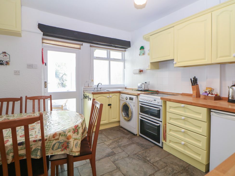 A kitchen with dining table and appliances at Honeysuckle Cottage 
