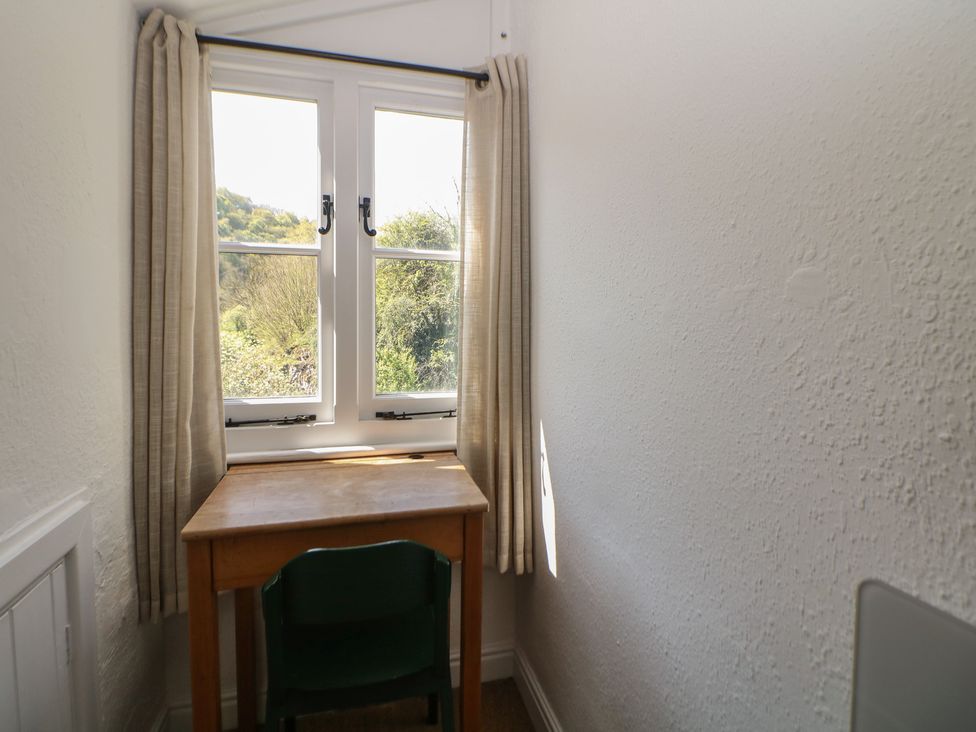 A study with a desk and chair next to a window at Honeysuckle Cottage 