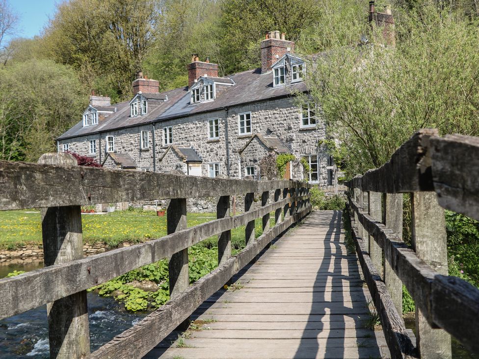 A house with a bridge in front at Honeysuckle Cottage