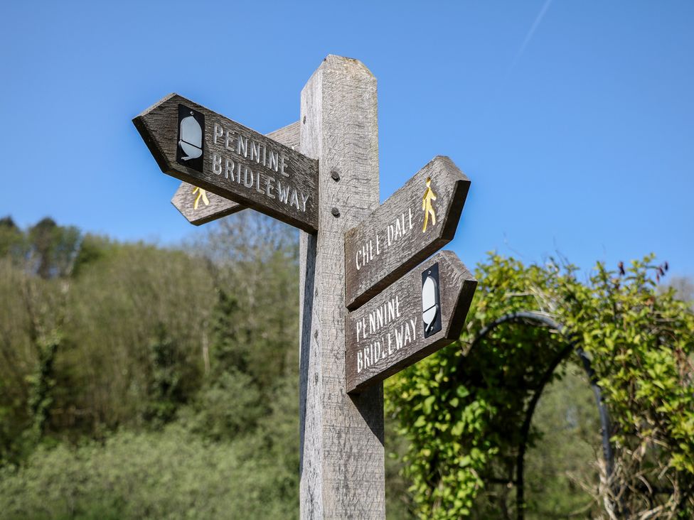 A signpost directing to Pennine Bridleway and Chee Dale at Honeysuckle Cottage 