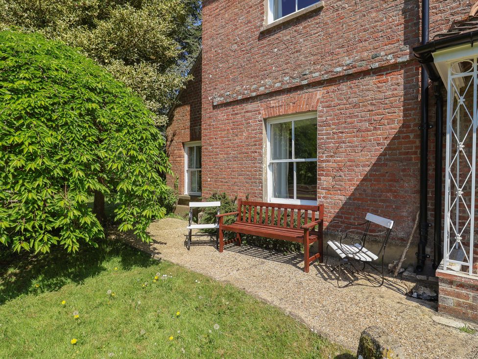 An outdoor area with a bench and chairs at Goulds Farmhouse in Milborne St Andrew